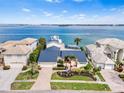 Gorgeous aerial view of a waterfront home with a blue roof, lush landscaping, and serene ocean views at 849 Harbor Is, Clearwater Beach, FL 33767
