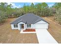 Charming single-Gathering home with a well-maintained lawn, light blue paint and attached two car garage at 14183 English Sparrow Rd, Weeki Wachee, FL 34614