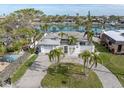 Waterfront home with palm trees, a brick-paved driveway, and canal access, located in a desirable coastal community at 193 Mar St, St Pete Beach, FL 33706