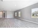 Spacious living area with three windows, hard surface floors, and neutral color palette at 2576 Pecan St, North Port, FL 34287