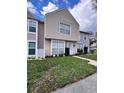 Inviting townhome showcasing manicured lawn, light siding, and white-trimmed windows and door at 16312 Rambling Vine W Dr, Tampa, FL 33624