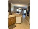 Kitchen with wooden cabinets, white appliances and view of dining area at 4939 Marina Palms Dr, Port Richey, FL 34668