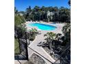 Community pool surrounded by lush landscaping and lounge chairs at 4939 Marina Palms Dr, Port Richey, FL 34668