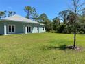 Spacious backyard with green grass, bordered by mature trees, perfect for outdoor activities at 1220 Gantry Rd, North Port, FL 34288