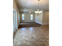Inviting living room with tile and carpet flooring, lots of natural light, and a modern chandelier at 1220 Gantry Rd, North Port, FL 34288