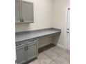 Home office features gray cabinets, granite countertop and neutral walls with tile flooring at 1608 Alliance Ave, North Port, FL 34286