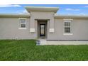 Charming home with a manicured lawn, decorative potted plant, and attractive neutral-toned exterior at 17663 Turning Leaf Cir, Land O Lakes, FL 34638