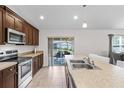 Bright kitchen featuring stainless steel appliances, wooden cabinets, modern countertops and a sliding glass door at 4196 Hoffman Ave, Spring Hill, FL 34606