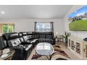 Comfortable living room featuring a large leather sectional couch, decorative rug and lots of natural light at 4196 Hoffman Ave, Spring Hill, FL 34606