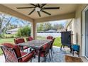Covered patio features an outdoor dining set, ceiling fan and a grill; great for entertaining and outdoor dining at 4196 Hoffman Ave, Spring Hill, FL 34606
