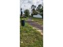 Walking path in the community, complete with trash receptacle, grassy area, and picnic seating at 13187 Gulf Bay Ln, Spring Hill, FL 34609