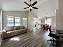 Open concept living room with wood floors, vaulted ceiling, and lots of natural light at 6212 Abbott Station Dr, Zephyrhills, FL 33542