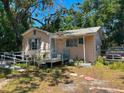 Exterior view of a single-story home with a ramp and overgrown landscaping at 665 36Th S Ave, St Petersburg, FL 33705