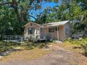 Exterior view of a single-story home with a ramp and overgrown landscaping at 665 36Th S Ave, St Petersburg, FL 33705