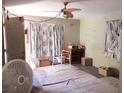 Living room with old flooring, ceiling fan, windows, and boxes and furniture at 665 36Th S Ave, St Petersburg, FL 33705