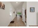 Bright hallway featuring wood-look tile flooring, leading to the open living spaces at 12905 Satin Lily Dr, Riverview, FL 33579