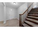 Bright entryway features wood-look flooring, leading to a staircase with carpeted steps and a wooden banister at 7105 N Whittier St, Tampa, FL 33617