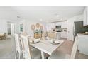 Open-concept dining area leading to a stylish kitchen with a dining table set for six at 9114 Gibralter St, Spring Hill, FL 34608