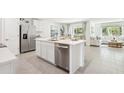 Modern kitchen with stainless steel appliances, a center island, and an open view into the living room at 9114 Gibralter St, Spring Hill, FL 34608