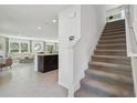View of open-concept design with staircase, modern tile flooring, and a spacious living area with ample natural light at 30948 Silver Stage Dr, Brooksville, FL 34602