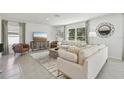 Comfortable living room with modern decor, large windows, stylish rug, and a cozy seating arrangement at 30948 Silver Stage Dr, Brooksville, FL 34602