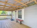 Inviting covered porch featuring wood flooring, overhead lighting, a window, and a comfortable bench at 6008 Angus Valley Dr, Wesley Chapel, FL 33544
