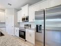 Modern kitchen with stainless steel appliances and white cabinets at 1696 Bendix Ter, North Port, FL 34286