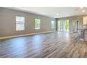 Bright, open living room featuring hardwood floors and sliding glass doors at 1696 Bendix Ter, North Port, FL 34286