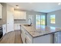 Close up of a kitchen island with gray granite countertops, cabinets, and a stainless-steel faucet at 2223 Hattie Ct, North Port, FL 34288