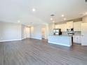 Open-concept living space featuring modern floors and a view of the kitchen and laundry area at 2223 Hattie Ct, North Port, FL 34288