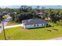 Aerial view of a single-Gathering home with lush landscaping on a spacious lot, showcasing its serene setting at 2423 Sadnet Ln, North Port, FL 34286