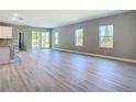 Bright, open-concept living area features modern gray walls, light wood floors, and large windows with plenty of natural light at 2423 Sadnet Ln, North Port, FL 34286