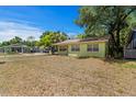 Quaint single-story home with a traditional design, showcasing its front lawn and mature trees at 107 W Woodlawn Ave, Tampa, FL 33603