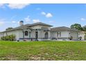 Beautiful single-story home with white stucco, arched windows, double door entry and manicured front lawn at 5188 Elwood Rd, Spring Hill, FL 34608