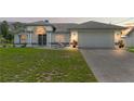 Charming single-story home featuring white exterior, gray accents, well-maintained lawn, and an attached two-car garage at 5188 Elwood Rd, Spring Hill, FL 34608