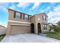 Inviting home boasts a well-manicured lawn, charming architectural details, and a convenient two-car garage at 1739 Broad Winged Hawk Dr, Ruskin, FL 33570