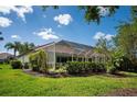 Expansive backyard features a screened-in lanai, mature trees, and verdant lawn at 3389 Pennyroyal Rd, Port Charlotte, FL 33953