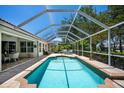 Inviting screened-in pool area is equipped with ample seating and brick paver surround at 3389 Pennyroyal Rd, Port Charlotte, FL 33953