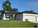 A well-maintained home featuring green landscaping, a white exterior, and a dark roof at 4097 Feather Ter, North Port, FL 34286