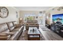Cozy living room featuring wood floors, neutral paint, large windows, and comfortable seating at 2401 Ecuadorian Way # 45, Clearwater, FL 33763