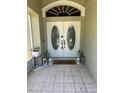 Inviting entryway features double doors with glass inserts, a welcome mat, and stylish lanterns at 9685 Southern Belle Dr, Weeki Wachee, FL 34613
