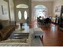 Spacious living room and dining room area with hardwood floors, elegant decor and plenty of natural light at 9685 Southern Belle Dr, Weeki Wachee, FL 34613