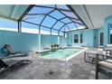Screened-in pool area featuring a tranquil fountain and comfortable lounge seating at 10391 Coquina Ct, Placida, FL 33946