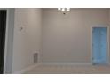Minimalist living room with neutral walls, carpet flooring, and modern lighting fixtures at 13243 Gulf Bay Ln, Spring Hill, FL 34609