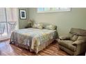 Cozy bedroom featuring wood floors, a comfortable bed, and a relaxing armchair at 1138 Lumsden Trace Cir, Valrico, FL 33594