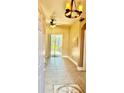 Light-filled foyer with decorative tile flooring, ceiling fan, and sliding glass doors to the backyard at 1138 Lumsden Trace Cir, Valrico, FL 33594