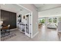 Bright, open-concept living room with dining area and view to study with paneled accent wall at 11352 Curio Dr, Brooksville, FL 34613