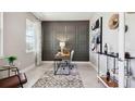 Office with desk, paneled wall, art, and large window letting in natural light at 11352 Curio Dr, Brooksville, FL 34613