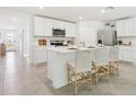 Bright kitchen featuring white cabinets, an island with bar seating, and stainless steel appliances at 11766 Memorial Dr, Brooksville, FL 34613
