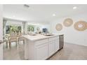 Bright kitchen with white cabinets, an island with seating, and an open concept to the dining area at 11766 Memorial Dr, Brooksville, FL 34613